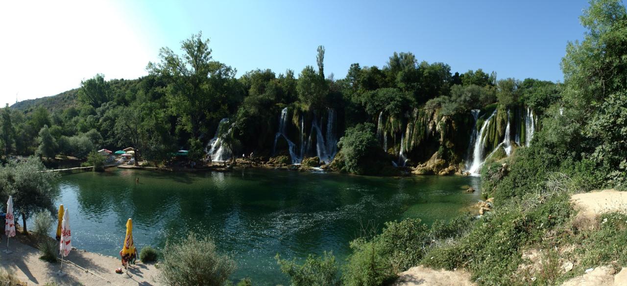 Wide travertine cascades and green swimming basin at Kravica Waterfall