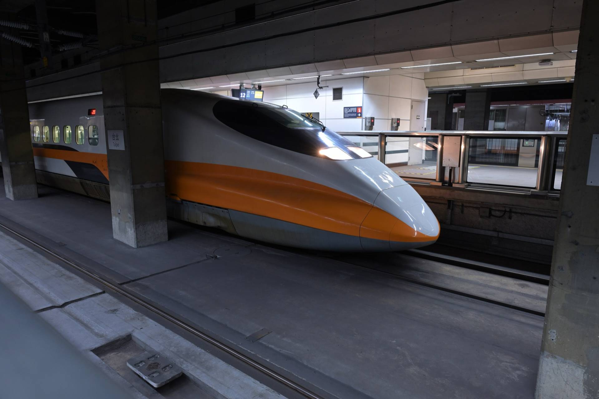 A Taiwan High Speed Rail 700T train with its orange and white nose waiting at an underground platform of Taipei Main Station
