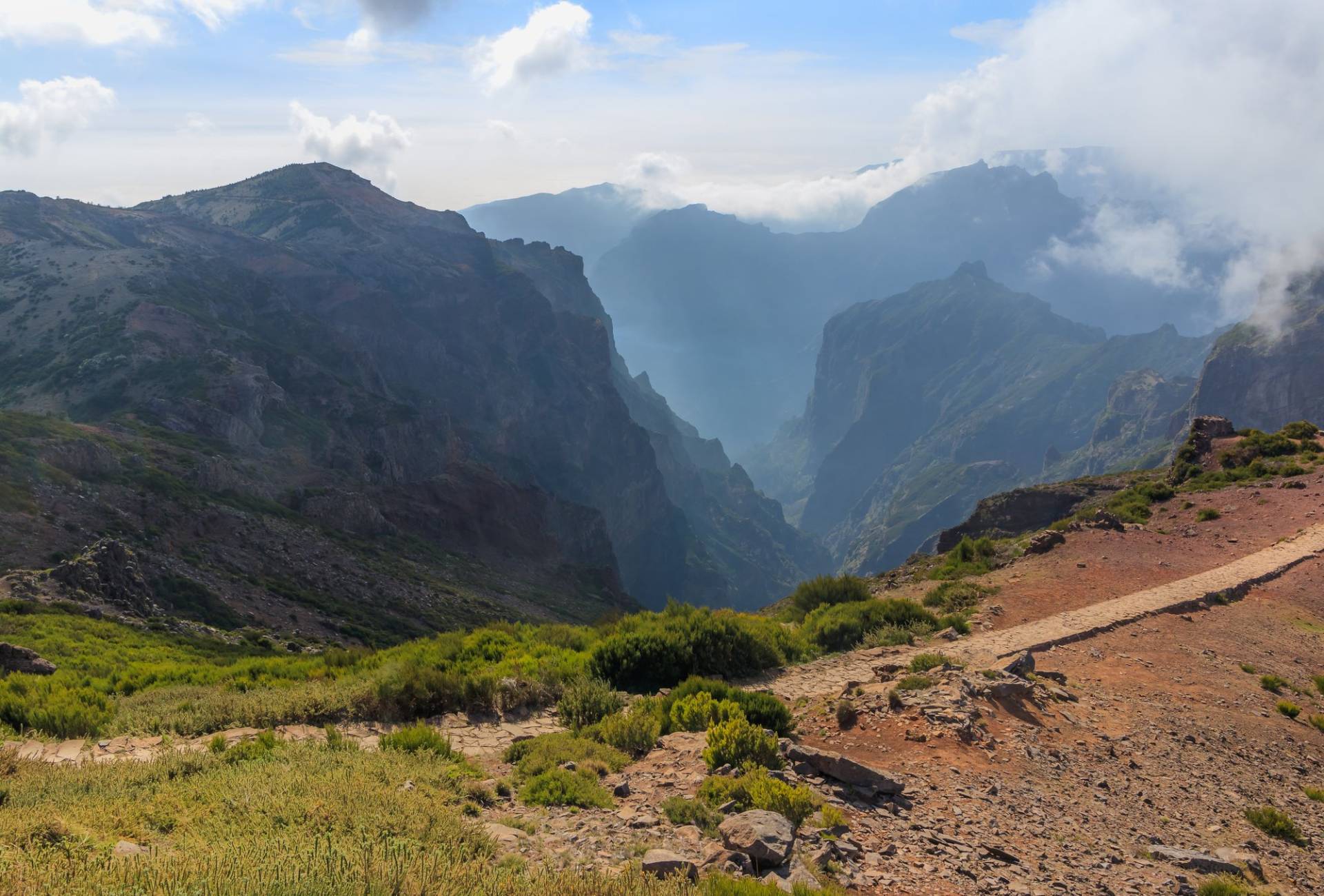 Rocky ridges of Madeira's central mountains seen from the Pico do Arieiro viewpoint, with cloud filling the valleys below the peaks